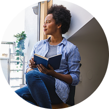 Woman with a book looking out into the distance